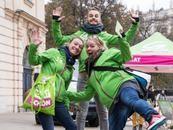Grüne Aktivistinnen und Peter Kraus lachen in der Kamera